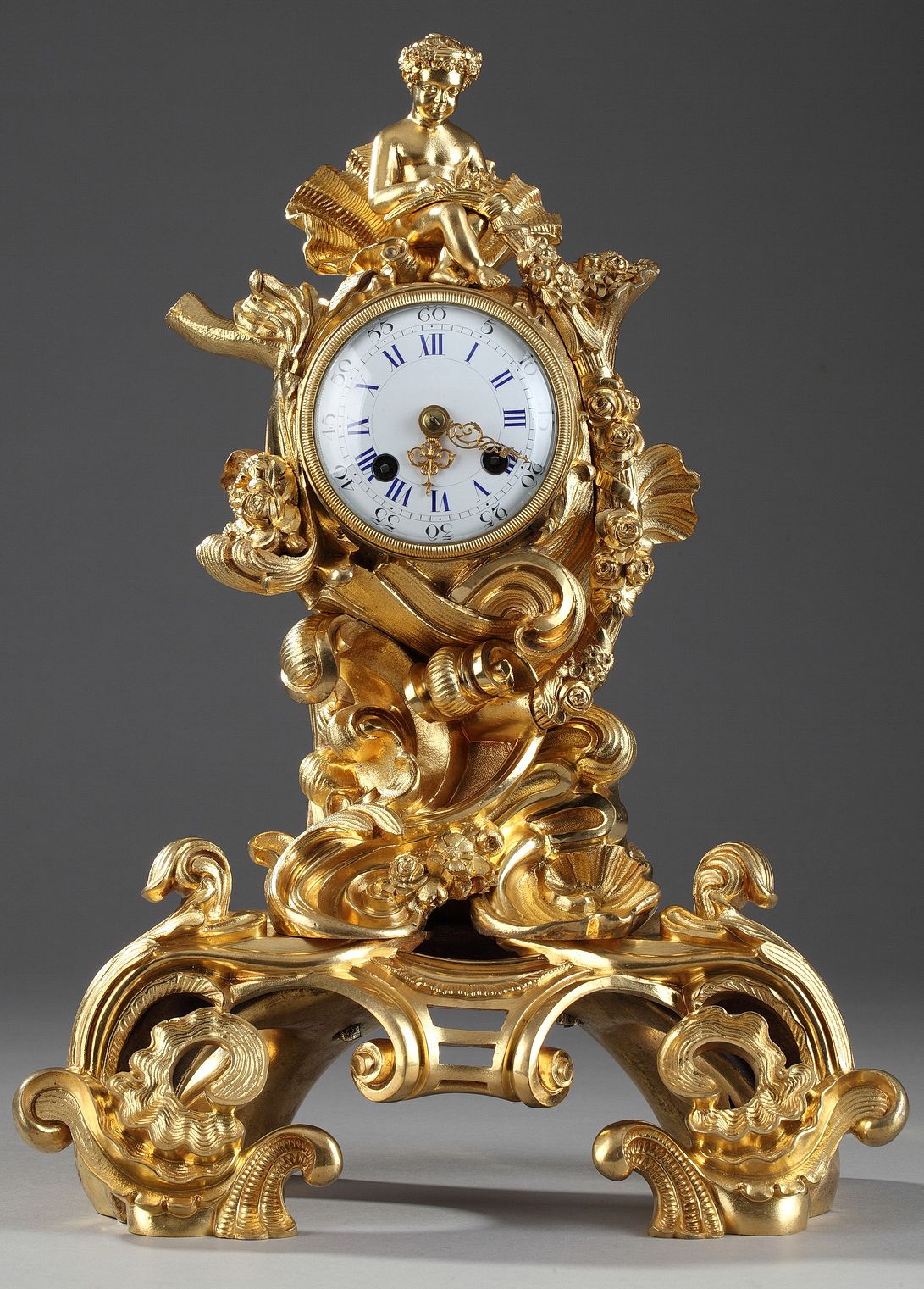 ROCAILLE STYLE CLOCK IN GILDED BRONZE, DECORATED WITH A PUTTO IN A SHELL 